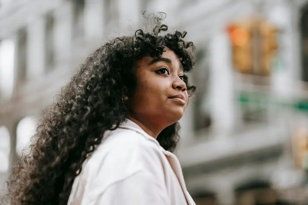 Woman looking ahead thoughtfully in a city setting, representing anxiety, self-reflection, and trauma therapy in Oakland