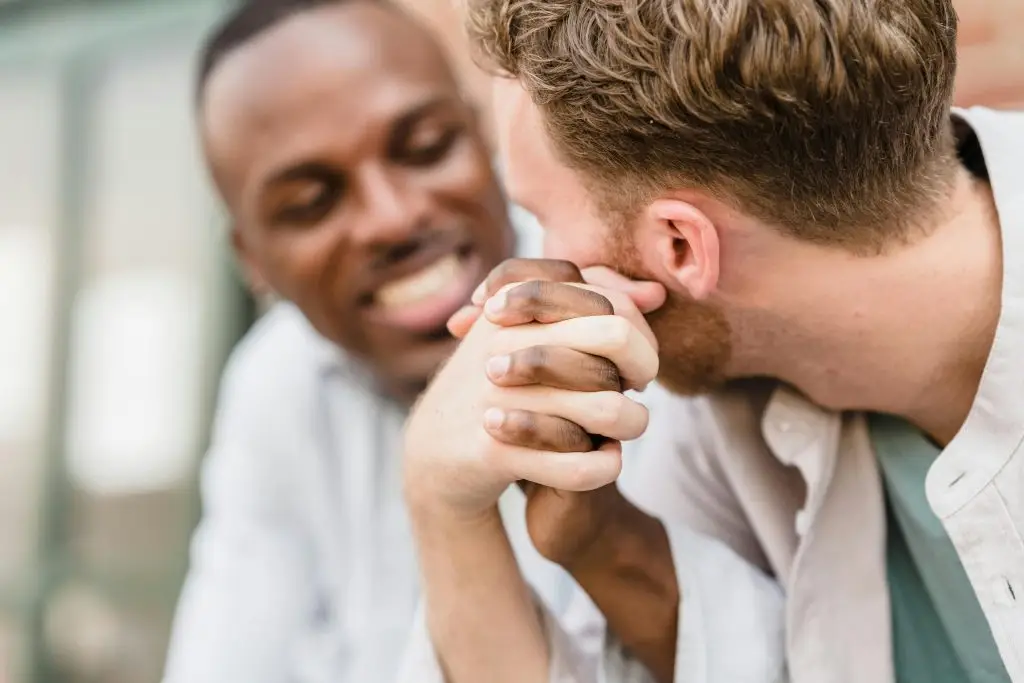 Two men holding hands, representing connection and healing in trauma-informed couples therapy Oakland