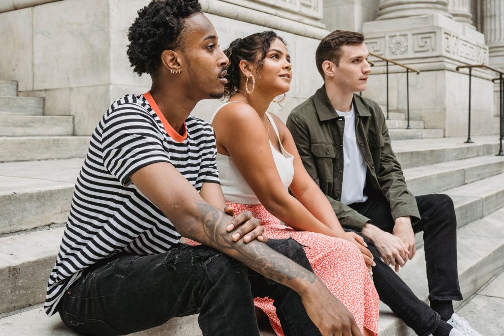 cnm-affirming-therapist / Three people sitting together on outdoor steps, reflecting the complexity of non-monogamous relationships and CNM therapy Oakland at Wildhaven Therapy