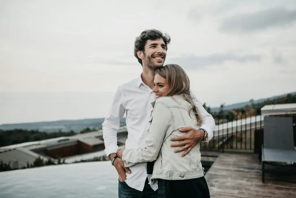 Couple embracing outdoors with a thoughtful expression, reflecting the emotional complexity of self-doubt in relationships and trauma therapy Oakland at Wildhaven Therapy