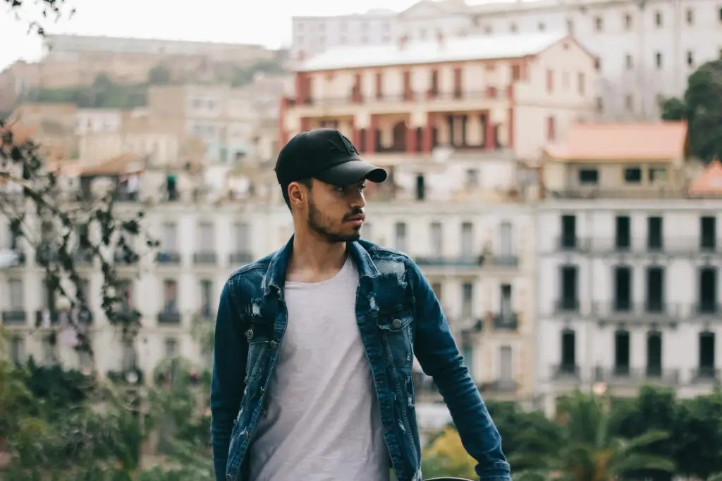 Young man standing outdoors with a thoughtful expression, reflecting the internal complexity of attachment trauma and IFS EMDR therapy at Wildhaven Therapy Oakland